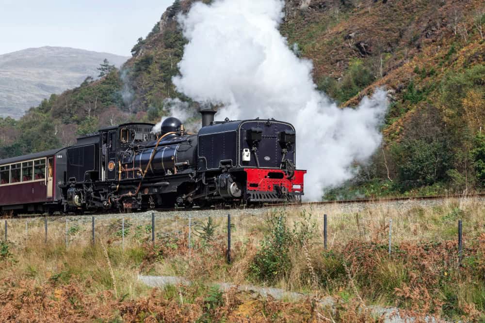 steam locomotive blowing out steam on the tracks